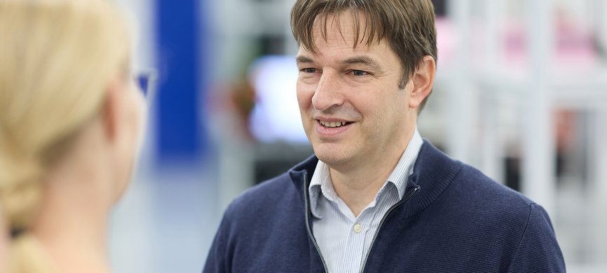 Geschäftsführer Thorsten Glück im Gespräch mit einer Mitarbeiterin bei GLÜCK Industrie-Elektronik im Rahmen der E²MS Elektronikfertigung.