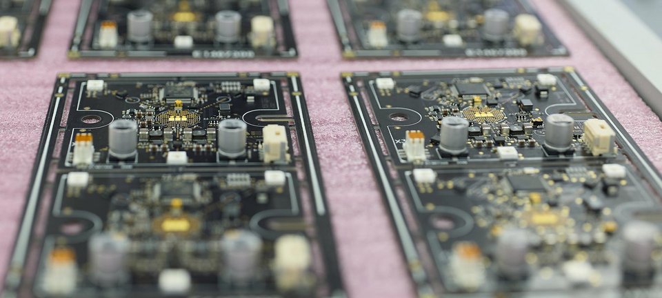 Bestückte Leiterplatten von GLÜCK Industrie-Elektronik auf einer ESD-Unterlage in der Fertigung.